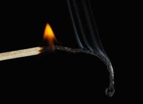 Burnout concept. Closeup of burning match, black background.