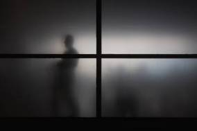68866673-silhouette-of-man-behind-window-with-matted-glass
